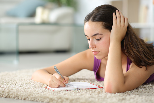 Woman writing in agenda on the floor