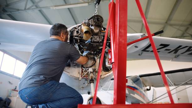 istock Aerospace industry. Aircraft mechanic repairs airplane engine. 1987155042