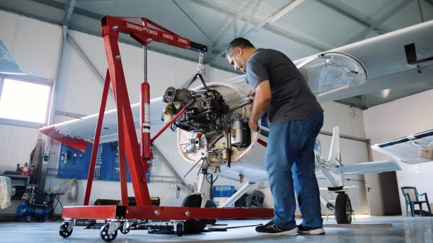 istock Aerospace industry. Aircraft mechanic repairs airplane engine. 1987155052