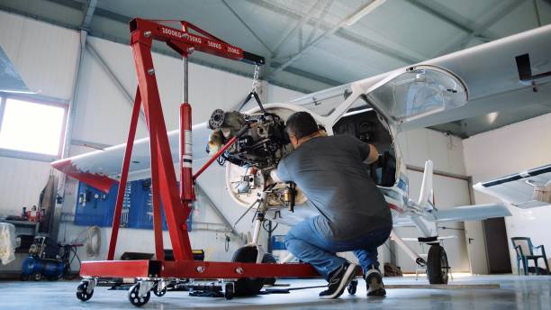 istock Aerospace industry. Aircraft mechanic repairs airplane engine. 1987155557