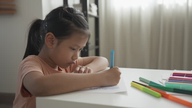 A girl enjoys drawing using colored pen