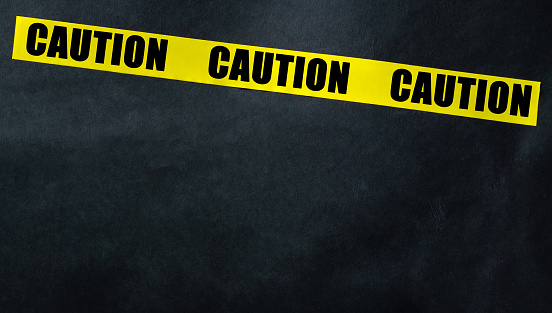 Caution Yellow Tape Strip On A Black Background