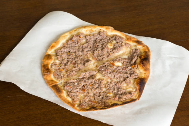 View of a Lahm bi ajeen meat pie, Middle Eastern flatbread and ground beef meat, on a table