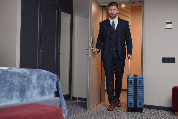 istock Businessman Entering Hotel Room with Suitcase 1987184035