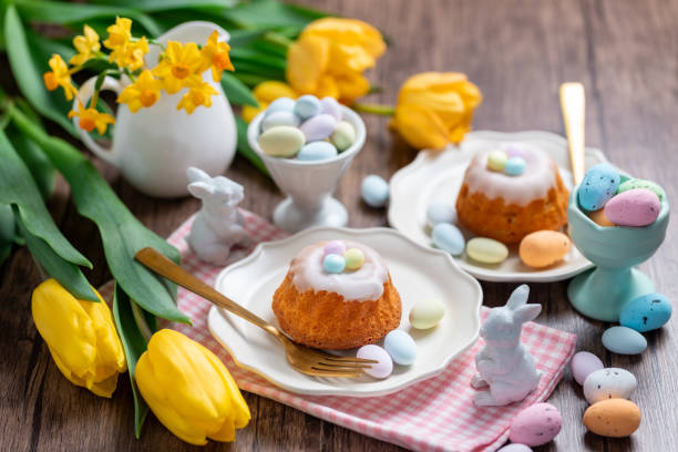istock Homemade delicious mini lemon bundt cakes and chocolate eggs on a easter table with fresh spring flowers. 1987195995