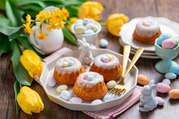 istock Homemade delicious mini lemon bundt cakes and chocolate eggs on a easter table with fresh spring flowers. 1987196500