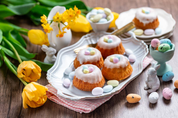 istock Homemade delicious mini lemon bundt cakes and chocolate eggs on a easter table with fresh spring flowers. 1987196504