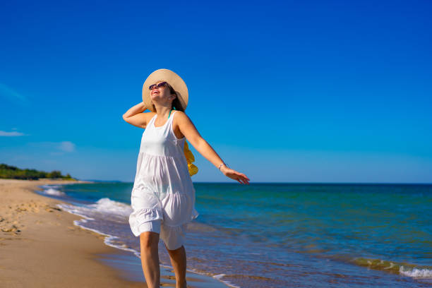 istock Beautiful woman walking on beach 1987207357