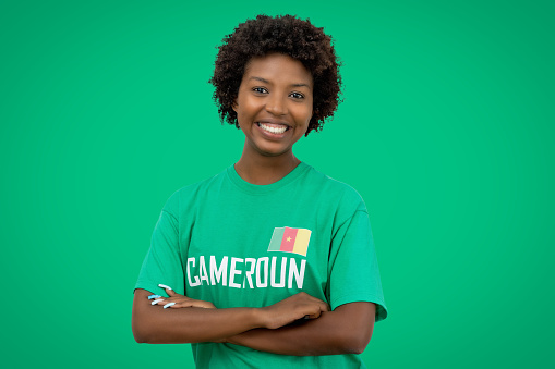 Beautiful football supporter from Cameroon with green jersey on green background
