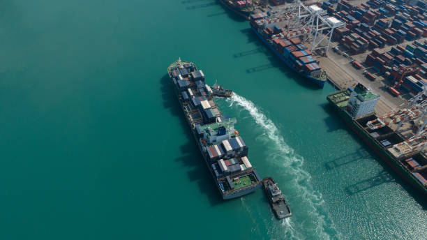 istock Aerial top view over international containers cargo ship at industrial import-export port prepare to load containers with big container loader ship vessel. global transportation and logistic business. 1987221044