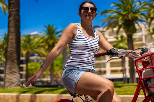 istock Woman riding bicycle on seaside boulevard 1987223148