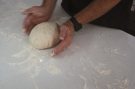hands forming dough into bread