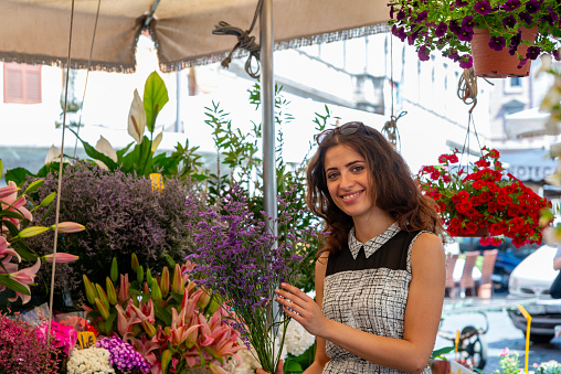 Young woman buying a bouquet at a flower market in Rome, Italy.