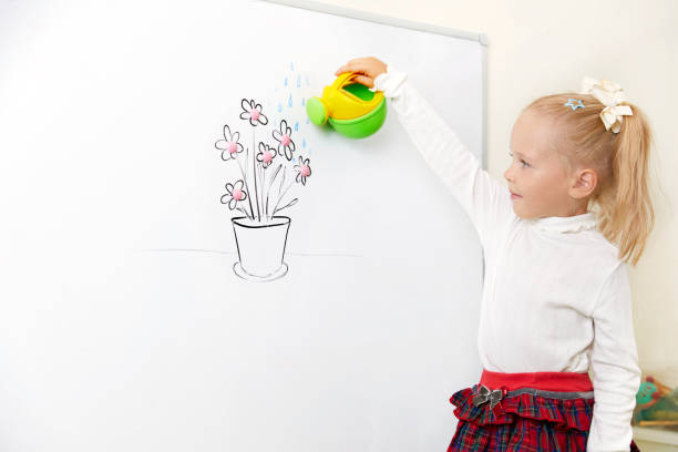 Little Girl watering flower drawing on a white board