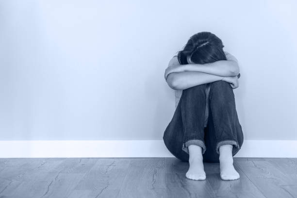 istock Sad woman sitting on a floor alone in empty room, despair and lonely concept with copy space 1987254690