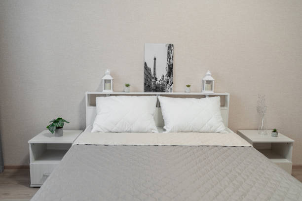istock bright bedroom with a large bed, bedside table, night light, light walls 1987255239