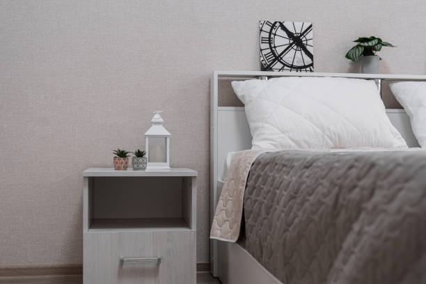 istock bright bedroom with a large bed, bedside table, night light, light walls 1987260027