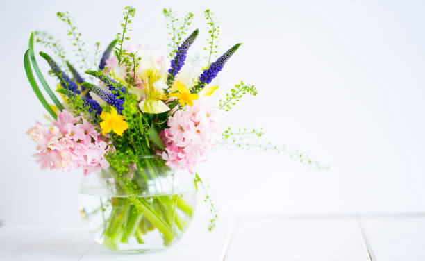 istock Delicate bouquet in a glass vase on a light background 1987275389