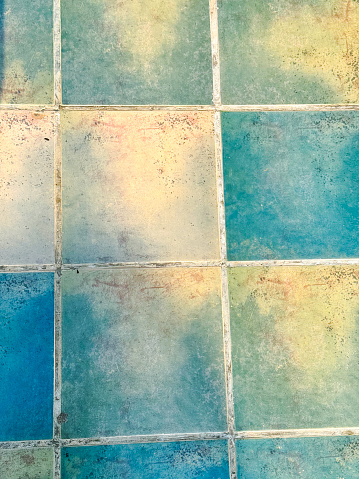 Stock photo showing close-up, elevated view of blue and cream coloured tile effect, vinyl flooring.