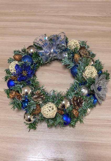istock Christmas wreath with blue and silver decorations on the wooden floor. 1987289832