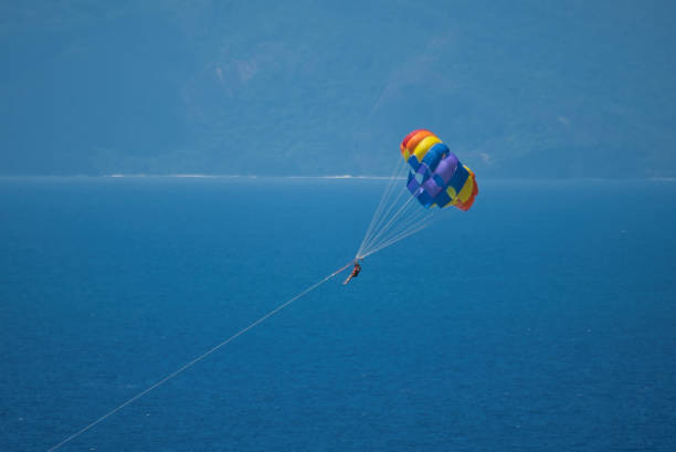 istock Single person parachuting at beau vallon beach 1987290902