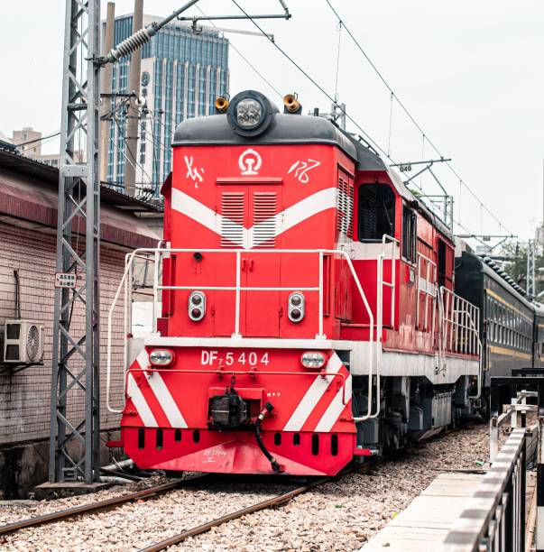 Wuhan, China – September 27, 2023: Train passing by a building and trees along the tracks