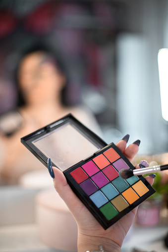 An unrecognizable make-up artist working at her studio