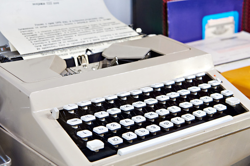 Closeup of a vintage typewriter with blank paper - horizontal image with copy space.