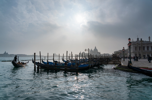 Looking out across a line of gondolas on the magnificent Grand Canal in Venice, with the majestically-domed Santa Maria della Salute Basilica in the background.