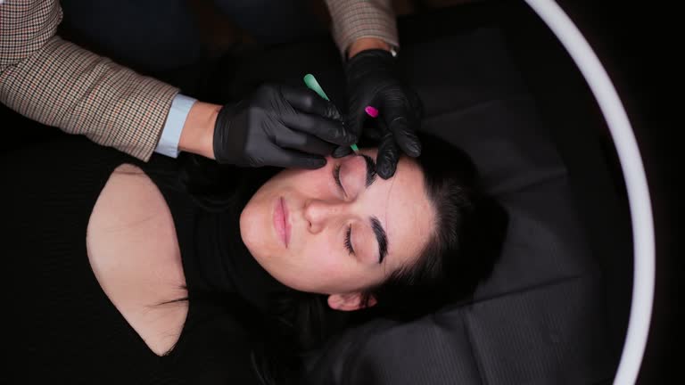 Young Woman Having Her Eyebrows Shaped At A Modern Beauty Salon