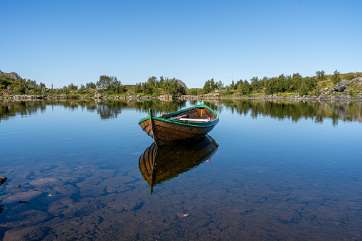 A Boat on tranquil lake water in Bleik Andoya, Norway