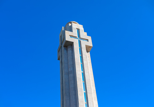 Cross on the top of the building against the blue sky. Cross monument at Plaza de Espana in Santa Cruz, Tenerife Spain