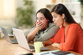 Shocked tele workers checking laptop at home
