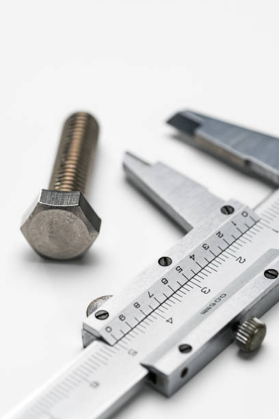 istock Metal vernier caliper and bolt on white background 1987358030