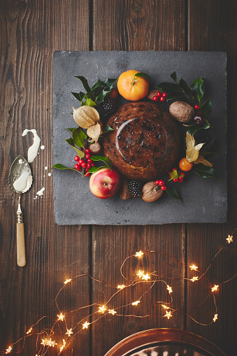 Fruit cake, plate and festive eating for holiday nutrition at thanksgiving for food event, Christmas or fairy lights. Dessert, sweets and above with spoon for dinner snack or cooking, cuisine or diet