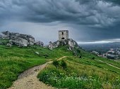 ruins of a castle in the mountains during a rainy day