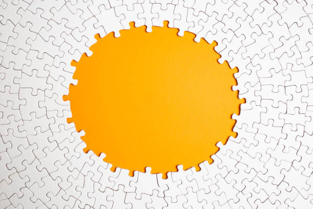 istock Plain white jigsaw puzzle  on yellow color background, oval shaped frame, abstract backdrop 1987460524