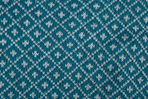 knitted blouse, with diamond shape pattern . abstract backdrop, close up