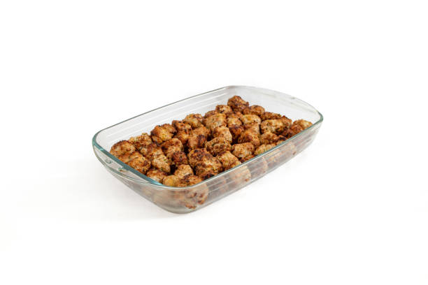 brown oven air fried meatballs in a glass tray, isolated on white - garlic roasted brown studio shot imagens e fotografias de stock