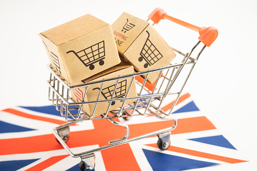 Box with shopping online cart logo and United Kingdom flag, Import Export commerce finance delivery trade.