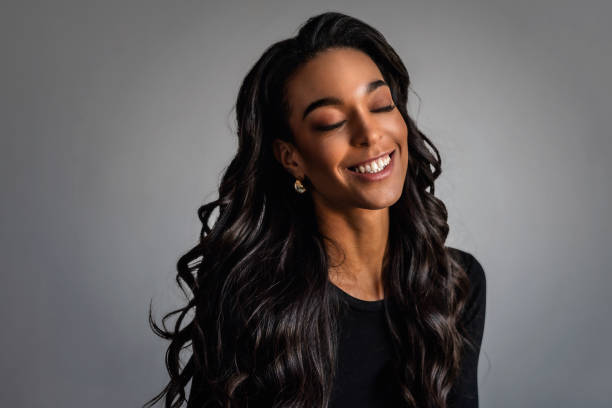 istock Attractive african american woman against grey background 1987485867
