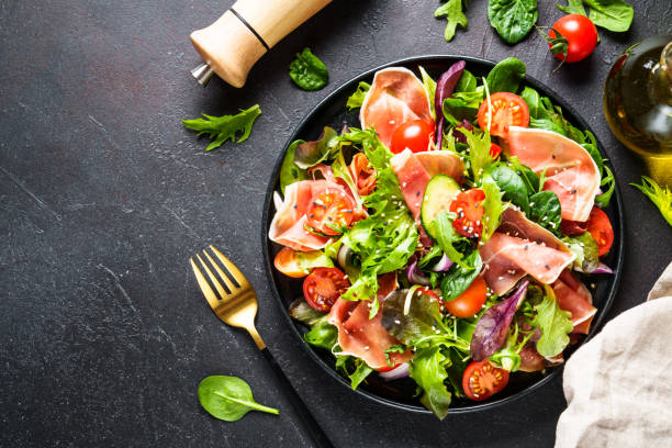 istock Salad in black bowl at dark background. 1987499813