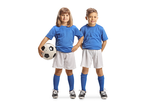 Boy and girl posing in blue and white football kits isolated on white background