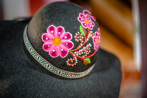 close up of a green felt hat embroidered with yellow pink orange fuchsia Alpaca wool headdress with embroidery at Arechipa in Peru