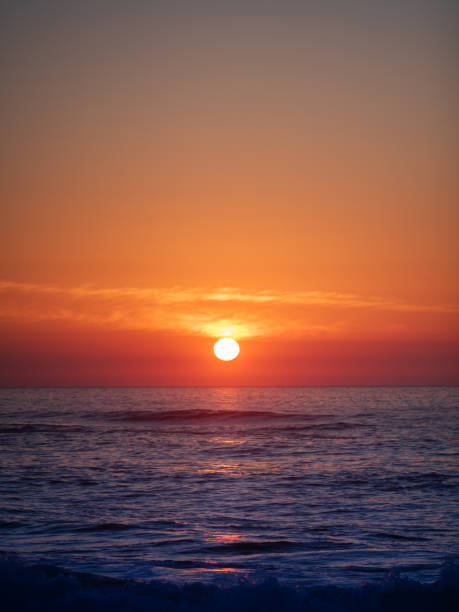 istock Bright sunset over the ocean with orange sky 1987587225