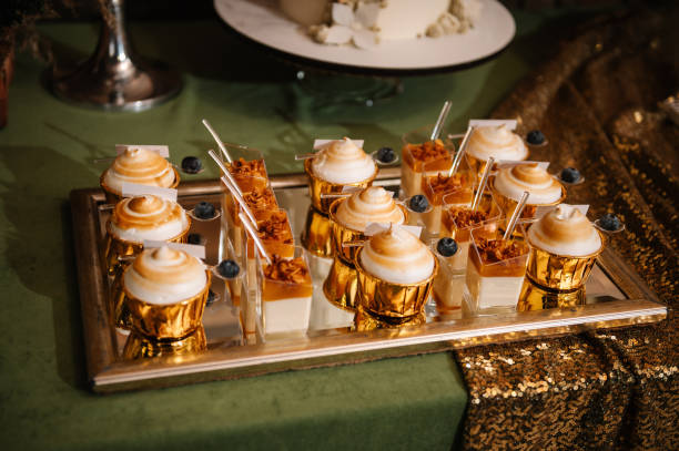 istock Delicious wedding reception with golden decor. Candy bar with desserts for celebrating birthday party. Table with sweets, candies, and dessert. Closeup. 1987604903