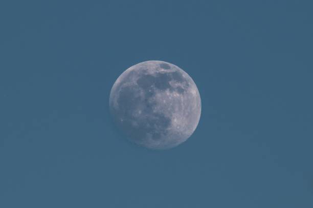 Moon in daytime against dark blue sky over Germany
