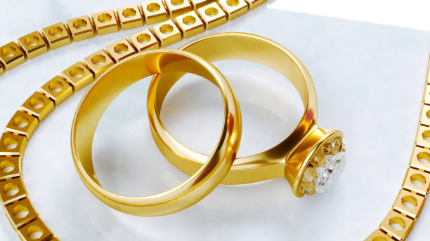 istock two golden wedding rings with golden chain isolated on grey background 1987629263