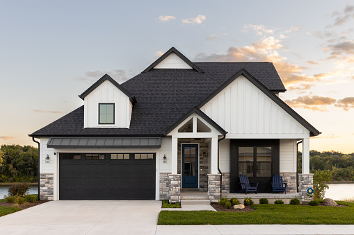 Beautifully landscaped custom dream home with circular concrete and brick driveway.