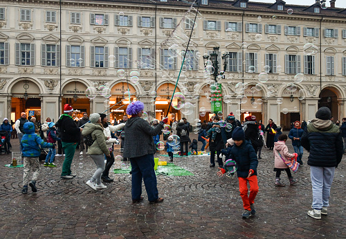 Turin, Piedmont, Italy - 12 09 2023: A street performer creating large soap bubbles for the enjoyment of adults and children in Piazza San Carlo, one of the main city squares in Turin.
